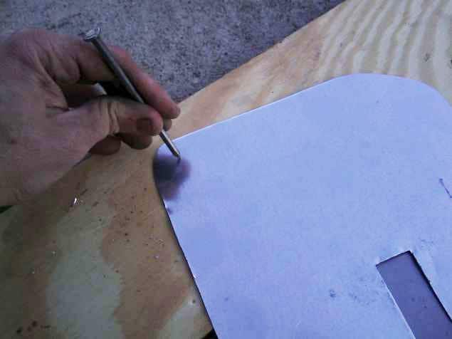 Figure 12: Using a hammer and nail to dent the heat shield